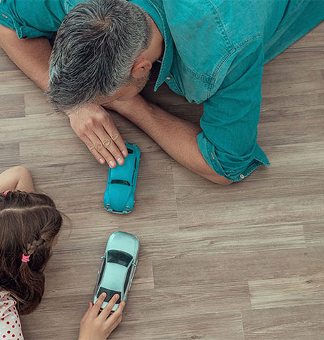 Man and child playing with toy cars on clean vinyl floor | Flooring Express | Lafayette, IN