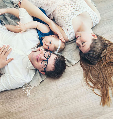 a family lays on clean laminate flooring | Flooring Express | Lafayette, IN